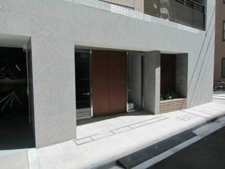 ウィルレーナ日本橋浜町エントランス｜エントランスは、天然石を使用した重厚な仕上げが高級感を演出。オートロックと宅配ボックスを備えた利便性と安心の導線設計。