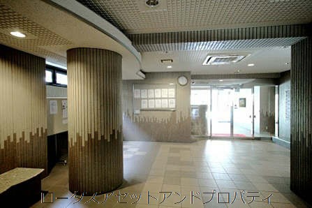ライオンズマンション門前仲町琴平エントランス｜エントランスホールは、吹き抜けはないものの、タイル床と折り上げ天井が整えられ、共用掲示板や管理室の掲示が整然と配置されています。