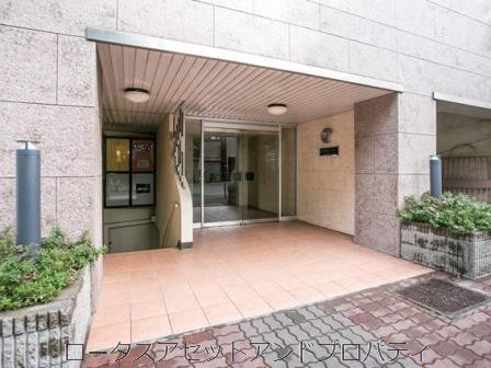 中野東豊マンションエントランス｜エントランスは、開口部の大きいガラス扉と植栽に囲まれたアプローチが、シンプルながらも清潔感のある印象を与えます。