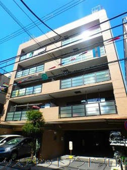 メイツ町屋7｜メイツ町屋はベージュ系タイルを基調とした落ち着きある外観が特徴の8階建マンションです。エントランスまわりの植栽が整えられ、清潔感が保たれています。