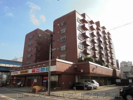 シャンボール高井戸は昭和４９年築、９階建てタイル貼りのマンションです。赤レンガ調の外壁が、都市生活の風景に溶け込む低層中層のフォルムです。1階部分にはテナントが併設され、生活導線の中に自然と商業が重なってくる構成に、都心マンションらしい機能性を感じます。環八通りに面しながらも、建物全体には一定の距離感が保たれていて、夕刻には車の流れとともに落ち着きが訪れています。
