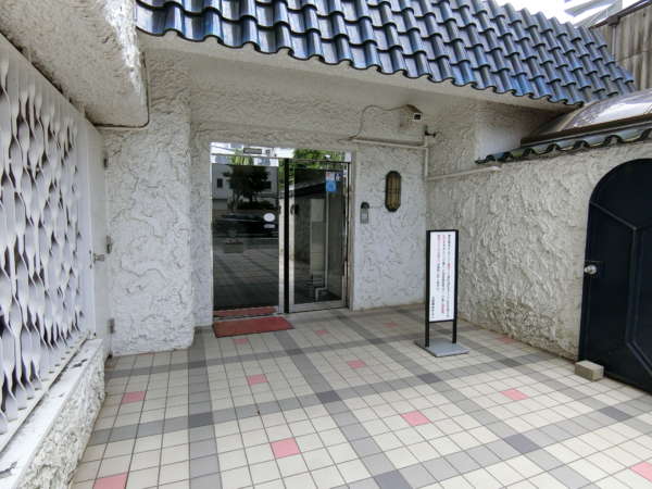 秀和豊玉レジデンス外観共用部1｜エントランスです。青いシールが貼付されているのが分かります。耐震改修をして新耐震相当になったことを認証する都のシールです。