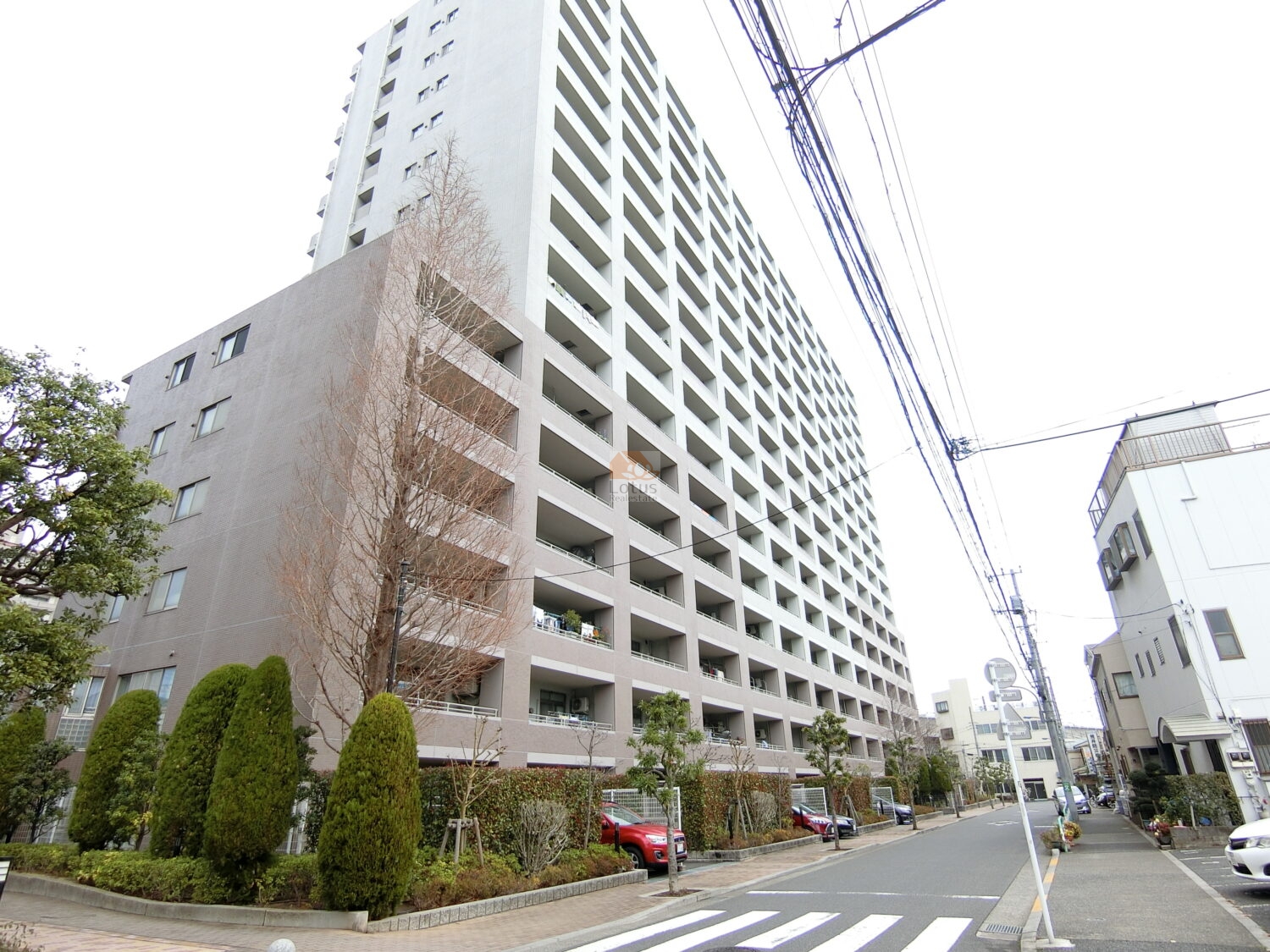 アクトピア北赤羽四番館は、平成15年築、縦に伸びる17階建てのフォルムと整然と配置されたバルコニーが視認性のあるファサードを形成。街路樹と植栽が歩道沿いに整備され、開放感のある街並みと調和しています。
