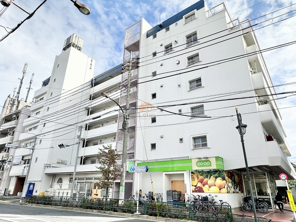 五日市街道沿いに面した外観は、白を基調としたシンプルな構成で、街並みの中でも輪郭がはっきりしています。低層住宅エリアが広がる第一種低層住居専用地域に隣接しつつ、視界が抜ける分、日中は空の明るさを素直に受け止める佇まい。生活動線の分かりやすさと視認性を重視した、実用性の高い外観といえます。