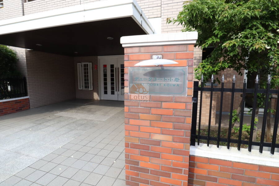 デュークコート小岩エントランス3｜デュークコート小岩マンションのエントランス3：照明付きの館銘板で。タイル張りの門柱が高級感を演出しています。