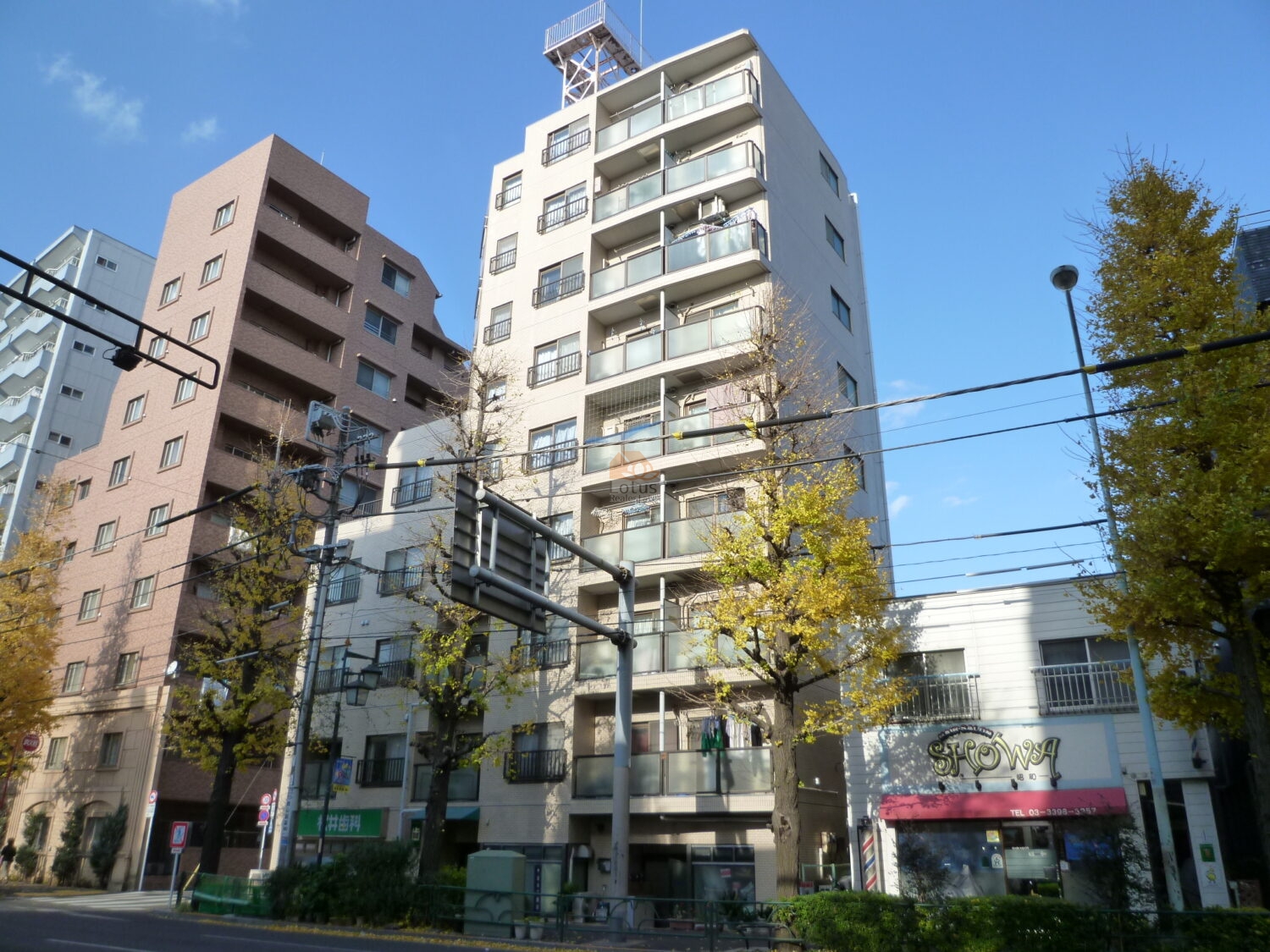 日興パレス西荻窪は昭和60年築、 青梅街道に面して立つ9階建の端正なフォルム。バルコニーの並びが整い、最上階には鉄塔構造が載るユニークな外観です。交差点に位置しながらも、街路樹と調和し、都市景観の一部として穏やかに佇んでいます。