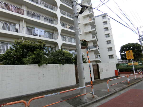 日商岩井竹の塚マンション外観共用部3｜外観です。南西南東にわけたＶ字型のファサードです。ちょうど扇の要の位置にエントランスがあります。