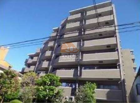 コスモ小豆沢公園の外観。8階建の中層マンション。タイル貼りの外壁が重厚感を演出し、周囲の緑と調和した落ち着きある佇まい。コスモ小豆沢公園は、平成９年築、８階建てのマンションです。