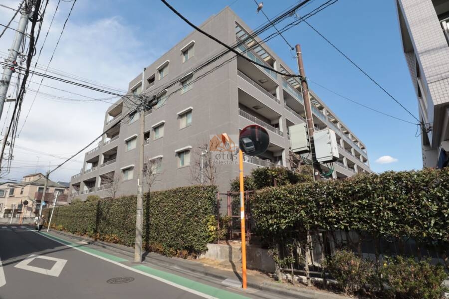 建物の側面はタイル貼りのグレー系外観で、周辺の住宅街に調和しつつも上質感を感じさせる仕上がり。角地に面しており、開放的なロケーションです。。