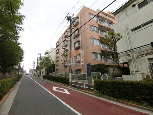 八幡坂のゆるやかな傾斜に沿って建つ外観がまず目に入ります。サーモン系のタイルが穏やかな印象で、山手線の内側とは思えない落ち着きがあります。建物の前を通ると車の音が少し遠くに聞こえる程度で、「駒込」「田端」駅徒歩10分圏内ながら閑静な住宅街に立地している特徴が伝わりやすい光景です。駒込八幡坂ガーデニアは、昭和61年築、8階建てのマンションです。