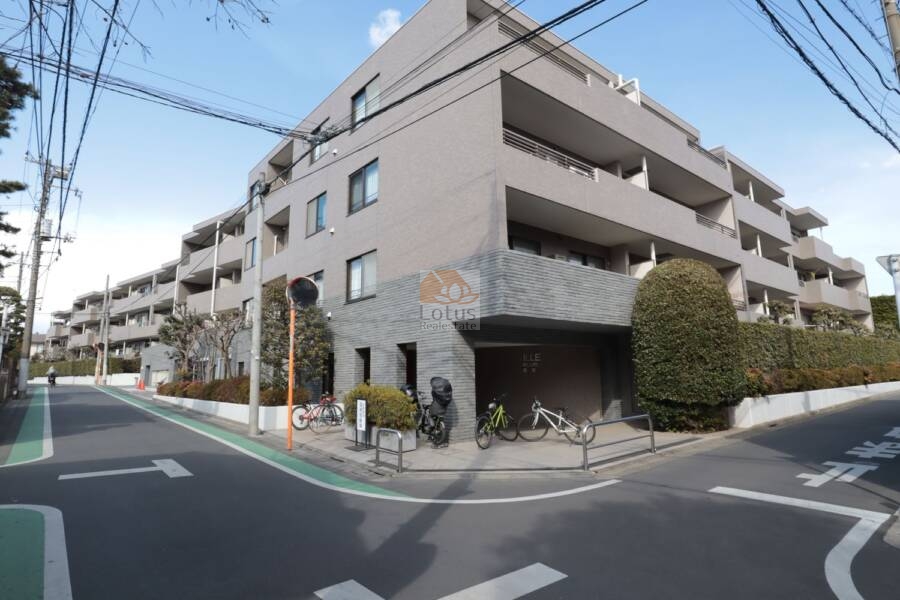 ヴィルヌーブ鷺宮外観11｜ゆるやかなカーブに沿って、低層ながらもボリューム感あるフォルムが印象に残る建物です。交差点に面した開放感と、落ち着いたタイル貼りの外壁が調和し、街並みに安心感を与えてくれます。