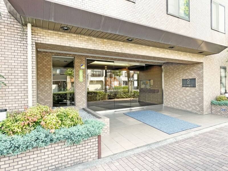 朝日クレス・パリオ西落合エントランス１｜エントランスはガラス扉と植栽で整えられた開放的なアプローチ。庇付きで雨の日でも安心の設計です。