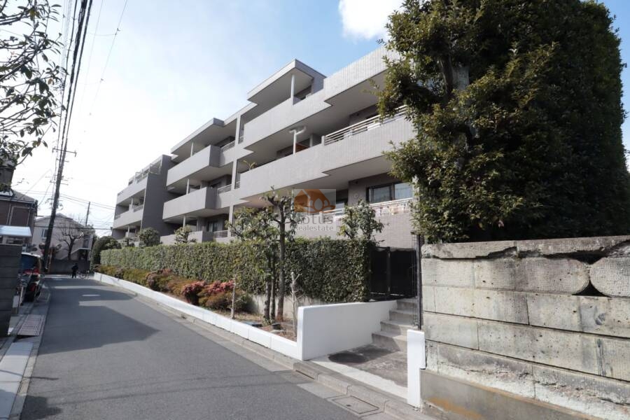 ヴィルヌーブ鷺宮外観33｜緩やかな勾配の通りに沿って、ずらりと並ぶバルコニーのリズムが印象的です。静かな住宅街の中でも、堂々たる存在感を放つフォルムに、安心感を覚えます。