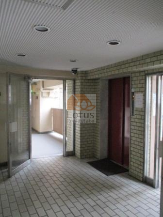 メゾンドール代々木エントランスホール２｜エントランス奥に続く廊下からは、落ち着いた照明と内装が印象的で、静かに住人を包み込んでくれるようです。外の喧騒とは対照的に、静けさと気品が漂います。