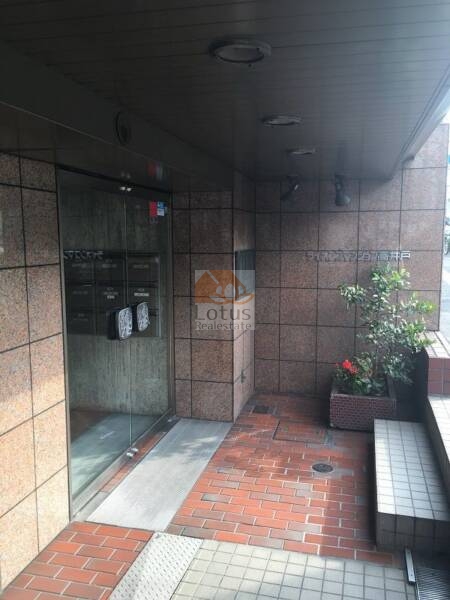ライオンズマンション高井戸3｜タイル敷きの床に沿ってガラス扉が設けられ、敷地内には植栽が配置されており、落ち着いた雰囲気です。