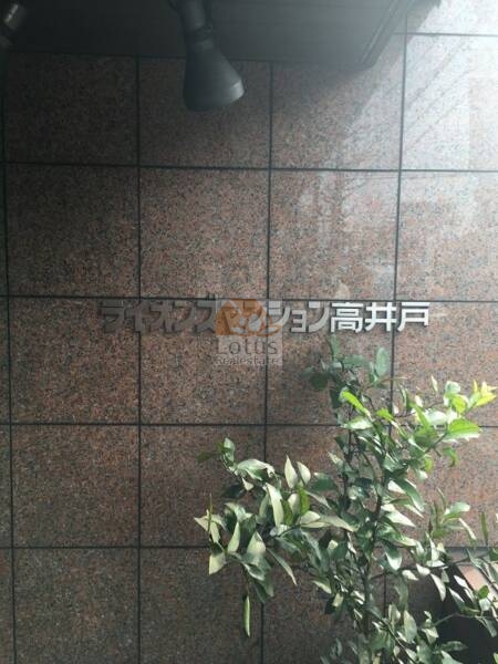 ライオンズマンション高井戸2｜壁面に設置されたステンレス製の物件名プレートが、視認性の高い位置に掲示されています。