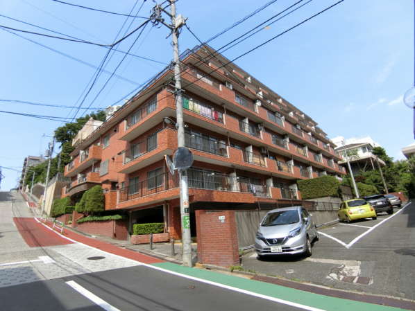 シャンボール第２目白外観共用部1｜南向きの傾斜地の下がりきる手前に位置しています。１階部分は半地下となり、駐車場となっています。南向きの日当たりは良好です。