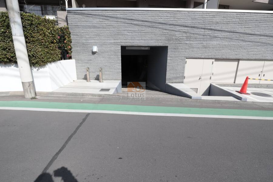 ヴィルヌーブ鷺宮共用部3｜こちらは地下駐車場のスロープ入口。周囲の植栽やカラー舗装が、安全性と美観の両立を感じさせます。出入り口には車止めポールも設置され、しっかりとした交通設計が伺えます。