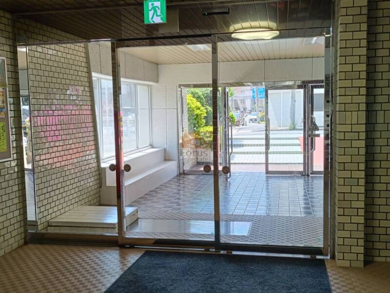 清澄ハイツエントランス２｜ガラス扉越しに明るい植栽が映え、安心感と開放感を同時に演出。住まいへの第一印象を爽やかに彩ります。