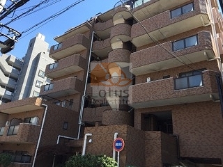 ライオンズマンション東日暮里第２の外観。ブラウン系タイル貼りの落ち着いたファサードに、リズムよく配置されたバルコニーが印象的。階段状の構成が、コンパクトながら立体的な表情を与えています。ライオンズマンション東日暮里第二は、平成元年築、7階建てのマンションです。