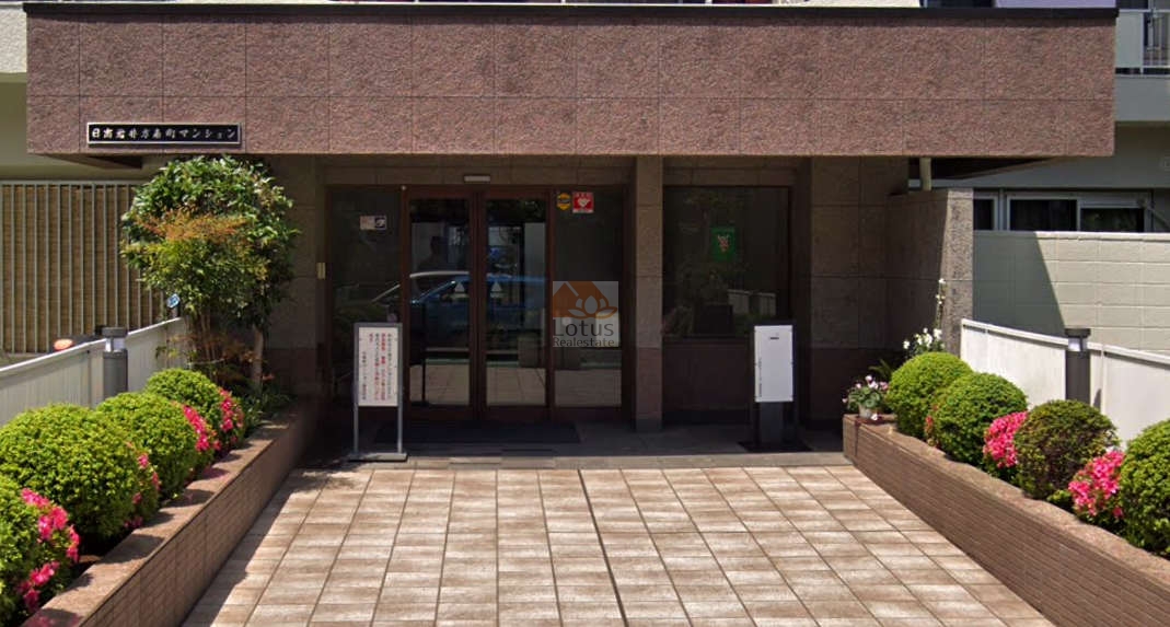 日商岩井方南町マンション (4)｜エントランスは、ガラス扉と整然とした植栽が印象的です。築年数を感じさせないよう整備されており、清潔感ある表情で迎えてくれます。