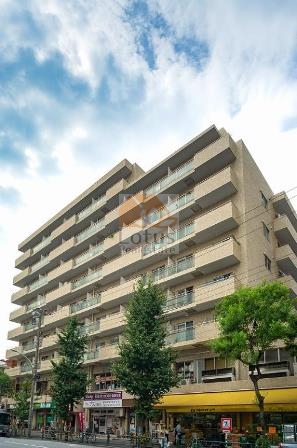 朝日動坂マンション外観4｜朝日動坂マンションの外観4は、歩道に面したファサードを捉えたショットで、視認性の高い商店街沿いの立地がわかります。周辺の街並みにも溶け込んだ安定感ある構造です。