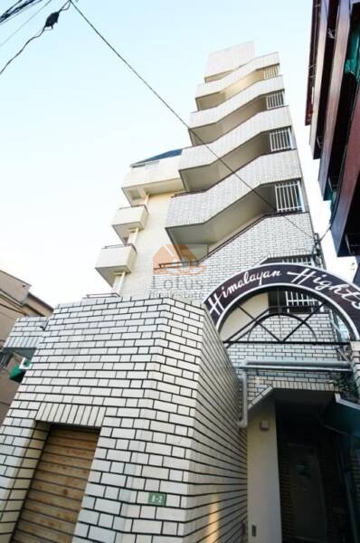 ヒマラヤンハイツ外観共用部7｜ヒマラヤンハイツは昭和57年築、6階建て、クリーム色のタイル張りで、アーチにネーミングが施されいます。