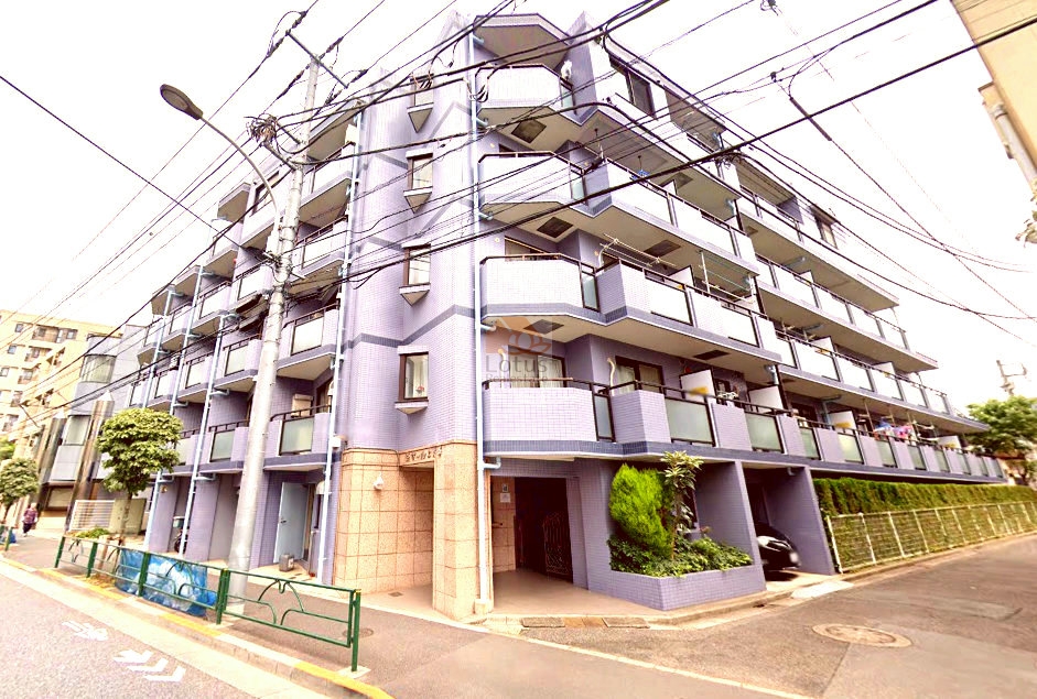 落ち着いたラベンダーグレーのタイル貼り外観が印象的です。建物は角地に建ち、道路に面したファサードには規則的に並ぶバルコニーがあり、日差しを取り込みやすい造りです。エントランスには石調のアクセントが施され、街並みに馴染みつつも存在感があります。セザール上井草は、平成8年築、5階建てのマンションです。