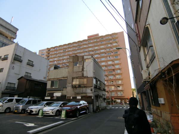築地永谷コーポラスアプローチ7｜南東に向かって歩いていきますと、もう物件はすぐ目の前です。築地永谷コーポラスのファサードが路地の先にあり、非常に存在感があります。