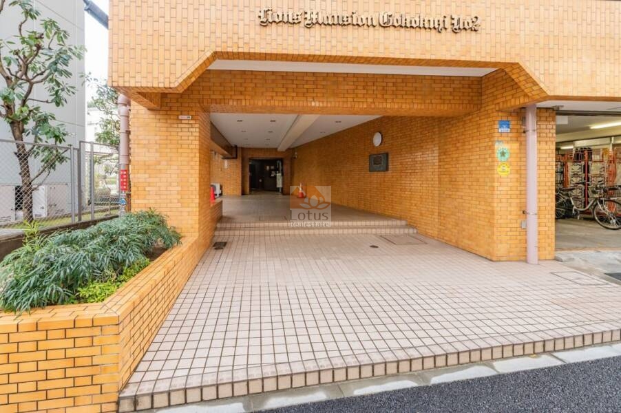 ライオンズマンション護国寺第２エントランス１｜雨除けのあるアプローチと植栽スペースが設けられ、住戸までの動線にゆとりがあります。
