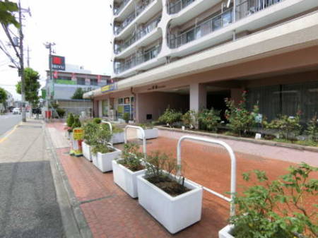 日商岩井綾瀬マンション　外観2｜マンションのエントランスに近づきました。１階はカレー店などが入居する商業スペースとなっています。