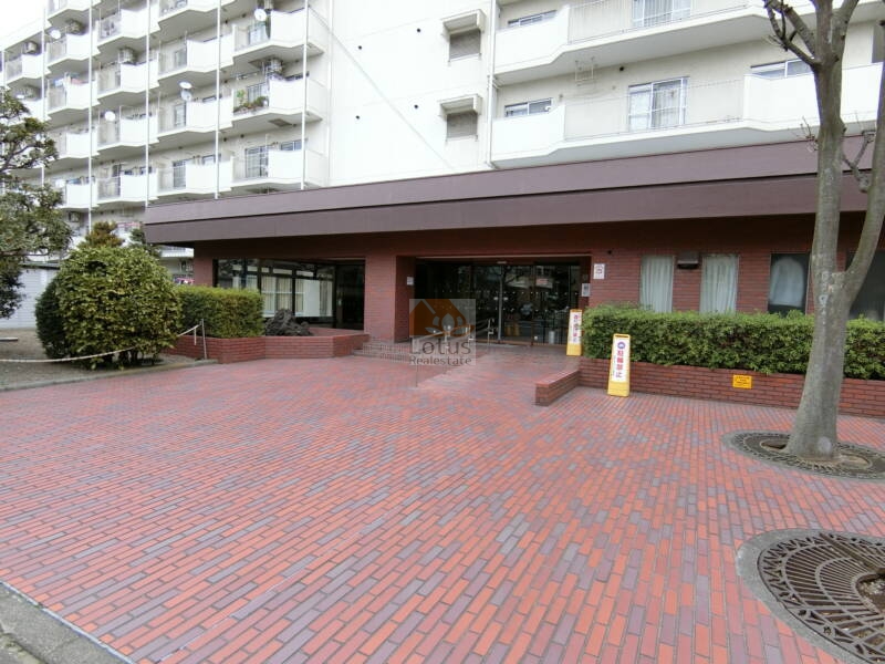 白鳥スカイマンション外観 (1)｜エントランス前は広く、茶色いタイルで舗装されています。