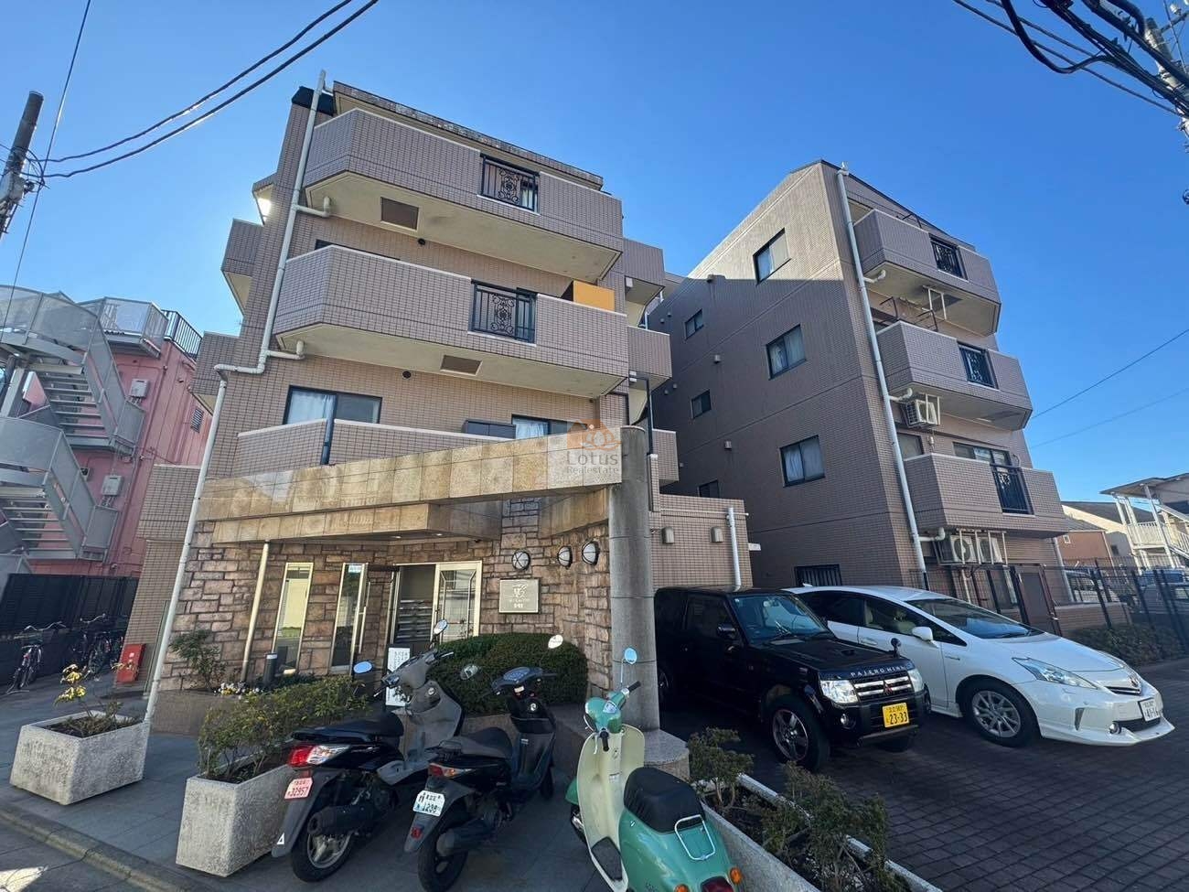 マイキャッスル竹の塚Ⅱは、平成11年築、ベージュ系タイル貼りの5階建で、道路に面した駐車場と植栽が整えられた落ち着いた佇まい。戸数23戸の中規模マンションで、日常生活に適した安心感のある住まいです。