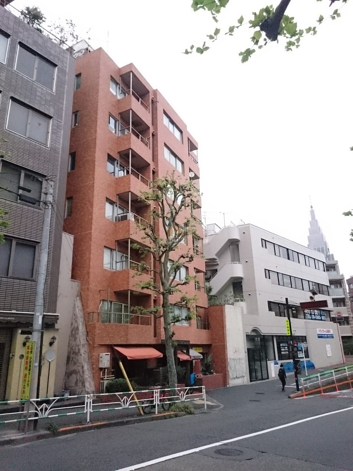 ライオンズマンション代々木の外観は、落ち着いた赤茶系タイル張りが特徴的で、通りから見上げると都市生活の風格が漂います。幹線道路に面しながらも、街路樹が目隠しとなって静かな印象を与えてくれます。