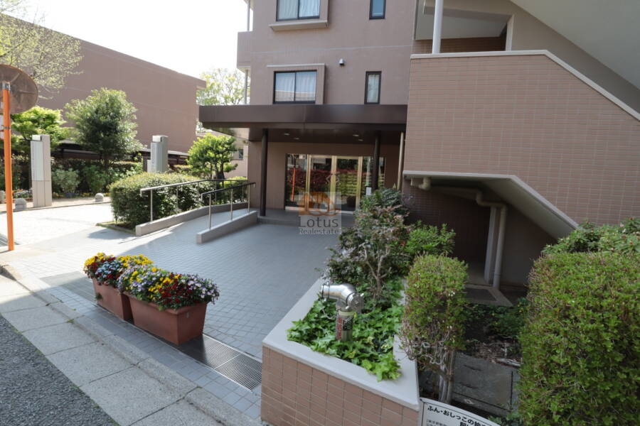 ファミールシティ武蔵関３番館エントランス2｜フラット設計と手すりが備わり、高齢者やベビーカーにも配慮されたアプローチです。