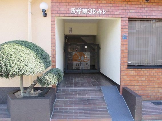 成増第３シャトレエントランス (1)｜エントランス横には管理表札が掲示され、マンションの運営体制を感じさせる造りです。小規模ながらも丁寧な印象を与えます。