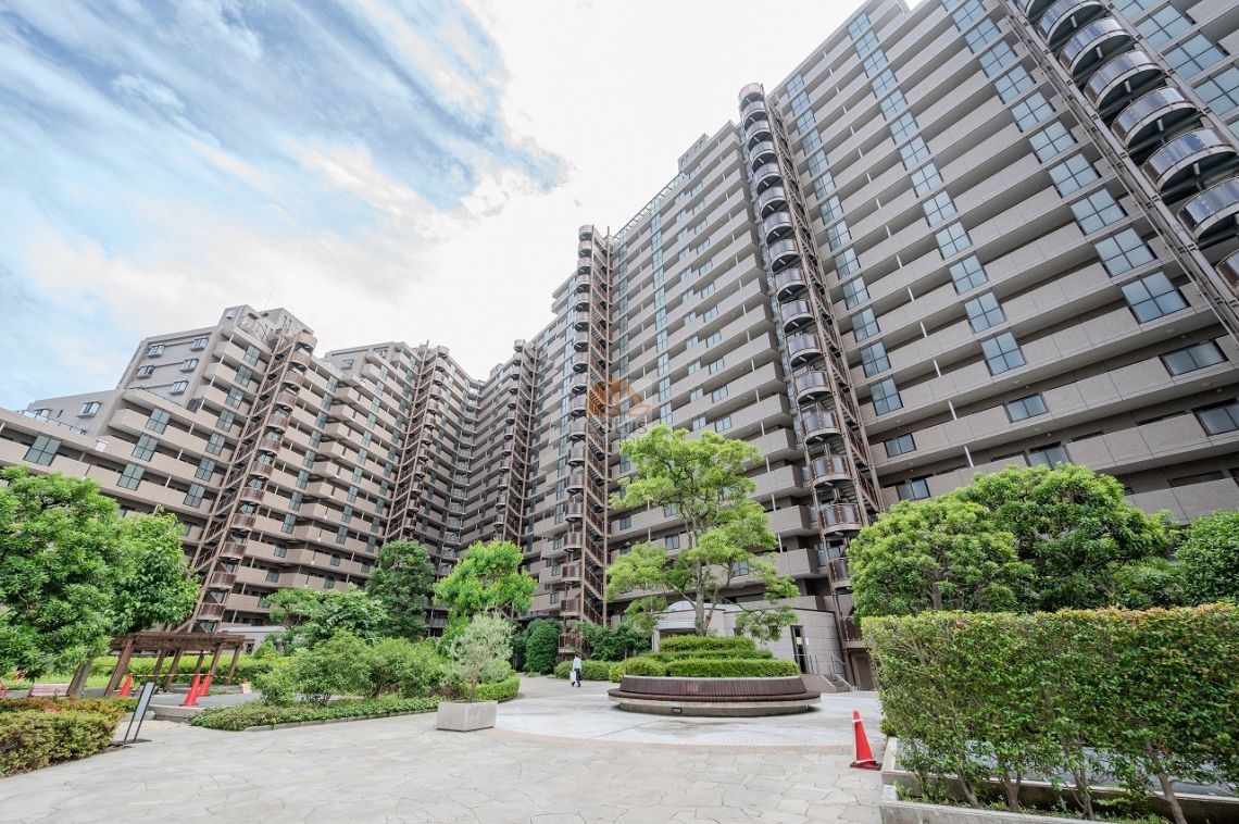 シスナブ池袋本町の外観。中庭を囲むように高層棟が立ち並び、大規模マンションならではの重厚なスケール感を感じさせる外観デザイン。緑豊かな植栽と整備された敷地が住まう人にゆとりを与える。シスナブ池袋本町は、平成9年築、19階建てのマンションです。