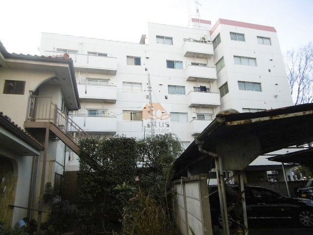 外観は白を基調としたシンプルなフォルムで、周囲の住宅街に溶け込む落ち着いた印象です。バルコニーのラインが整っており、手入れの行き届いた植栽が建物の雰囲気を柔らげています。