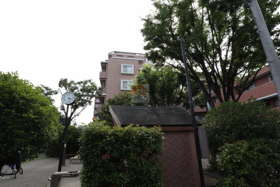 デュークコート小岩外観4｜デュークコート小岩マンションの外観4：建物の角部分と周囲の植栽が写っており、敷地のゆとりや街並みに調和した設計がわかります。