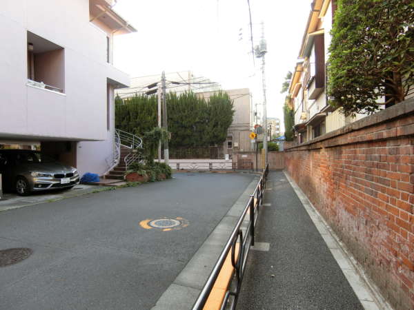 春日タウンホームアプローチ6｜春日通りから一本はいると、もはや落ち着いた住宅地になります。写真のサイドのレンガ風の壁はお寺さん（真言宗常泉院）になります。