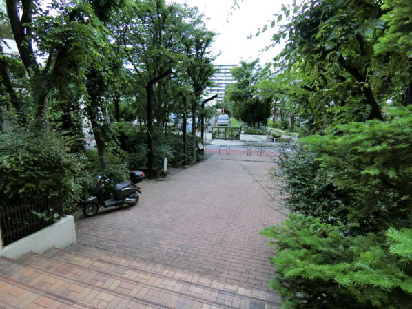 コープ野村大島外観共用部5｜エントランスの階段を上がったところで外側を向いています。植栽が大変多く、管理が行き届いている印象です。