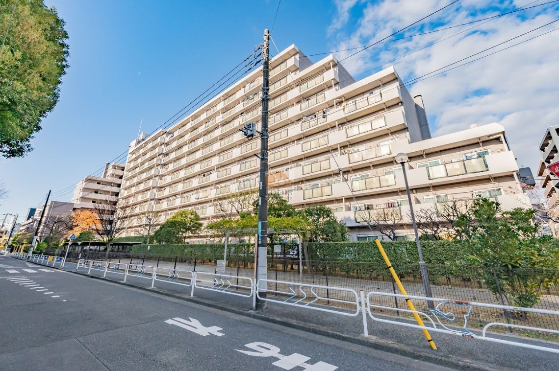 穏やかな色調でまとめられた外観が、周囲の住宅街に自然になじむ佇まいです。横に広がるプロポーションが印象的で、総戸数251戸(A棟・B棟)の大規模マンションらしいスケール感も伝わってきます。通りに面しながらも植栽で距離が取られ、日常の喧騒をやわらかく受け止める構成といえます。