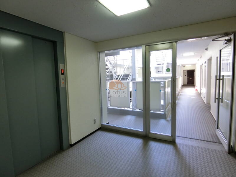 朝日動坂マンション共用部3｜朝日動坂マンションの共用廊下は外光が差し込む設計で、各戸のプライバシーを守りながらも開放感のある設計となっています。エレベーターホールもシンプルで使いやすく設計されています。