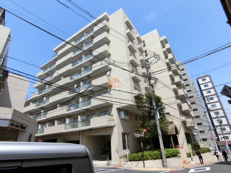 朝日動坂マンション外観1｜朝日動坂マンションの外観1は、白系タイル貼りのシンプルな外壁と整然としたファサードが特徴です。大通りに面しながらも、落ち着いた佇まいを保っています。