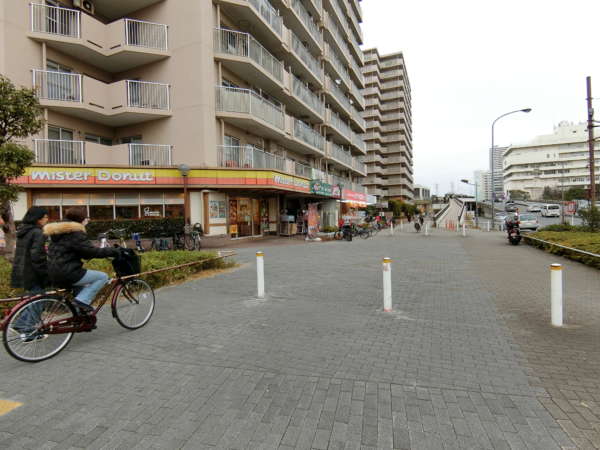 東大島ファミールハイツアプローチ1｜道路を渡るとミスタードーナツをはじめとした商店がありますが、すでに東大島ファミールハイツの敷地です。写真は１号館の一部です。