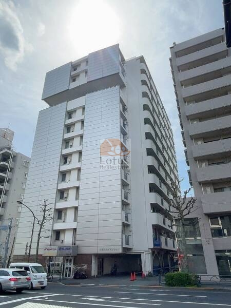 中野スカイマンション外観４｜中野スカイマンションは昭和48年築、青梅街道沿いにそびえる13階建の縦長フォルムが印象的です。ホワイトとシルバーを基調とした外装が、都心立地にふさわしい存在感を放ちます。