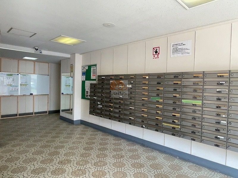 中野スカイマンションエントランス１｜エントランスホールには、ずらりと並んだメールボックスと掲示板が整備されています。床は丸模様のモザイクタイルで仕上げられ、築年数を感じさせない清潔感が保たれています。