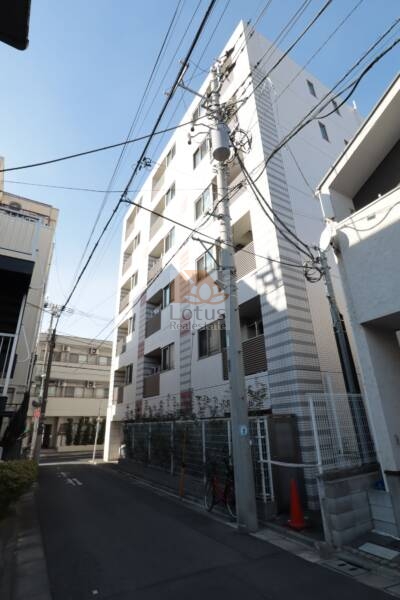 アークス鷺ノ宮外観2｜建物全体が確認できるカットで、穏やかな街並みに溶け込みながらも存在感のあるファサードが目を引きます。1階部分には駐車場スペースも確認でき、利便性の高い暮らしが想像できます。