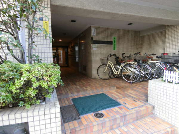 シティマンション上野外観共用部2｜こじんまりした小型マンションです。エントランスは駐輪場を兼ねます。