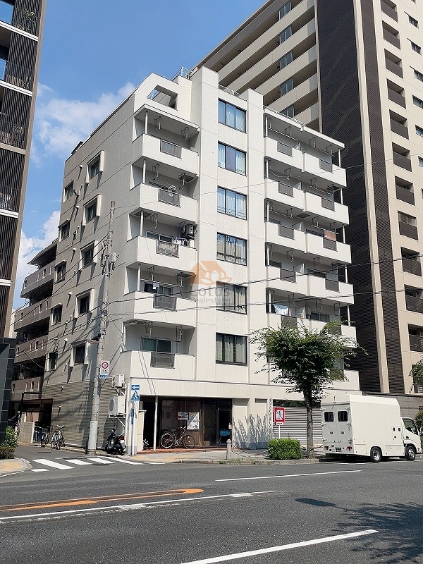 ソーケン日暮里マンションは昭和56年築、7階建てのマンションです。白を基調とした7階建ての外壁と、角地に位置する視認性の高い立地が確認できます。周囲の高層建物に挟まれつつも、しっかりと存在感を放っています。